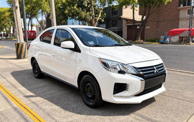 Sedán Mitsubishi blanco en calle urbana